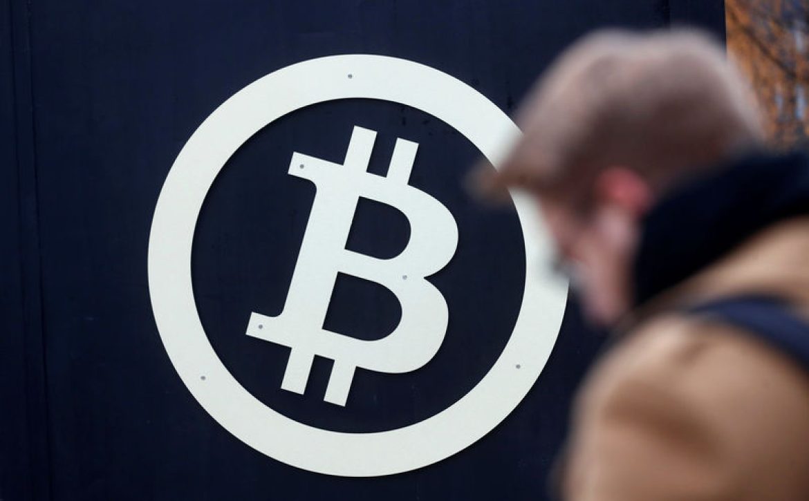 A bitcoin sign is seen during Riga Comm 2017 fair in Riga